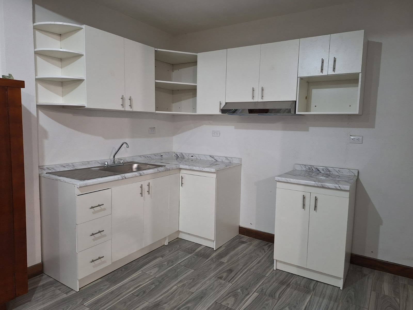 Cocina compacta blanca con top tipo mármol