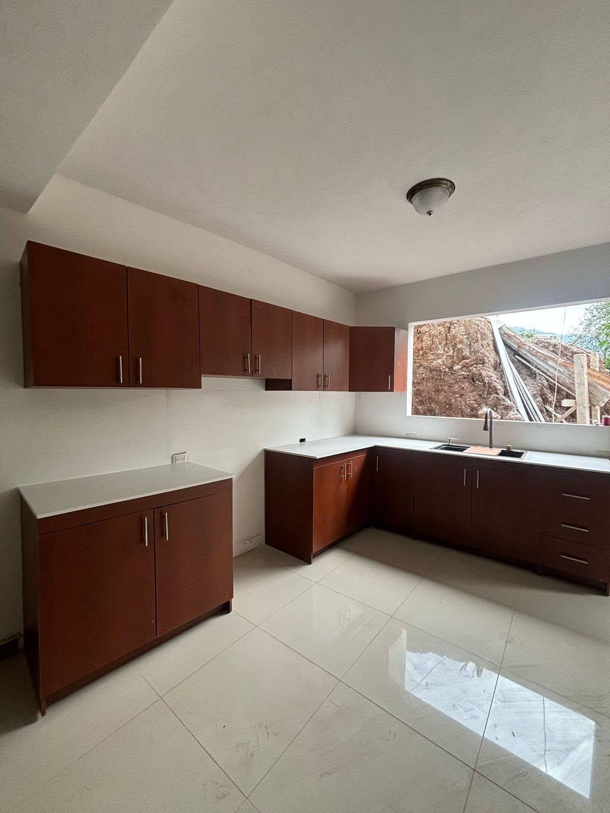Cocina integral en madera cálida y top blanco